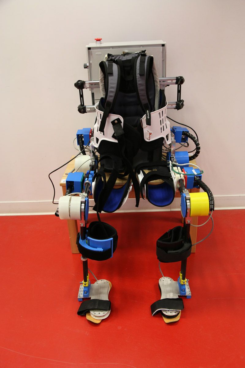 JUNIA 外骨骼全视图，显示绑在人体背部的机械装置，形似背包。