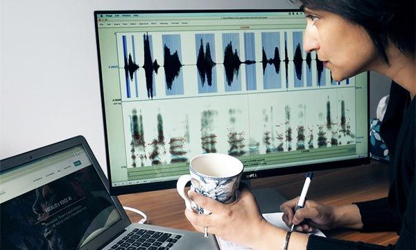 Rupal Patel looking at laptop. Computer screen with signal processing in background.