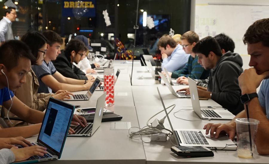 Students with laptops sitting along a long table in Drexel’s ExCITe Center.