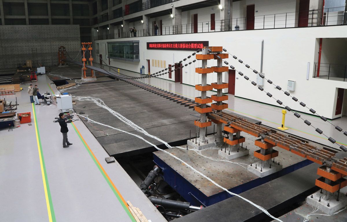 长悬索桥缩尺模型的抗震试验。振动台位于每座桥的垂直支撑结构下面。