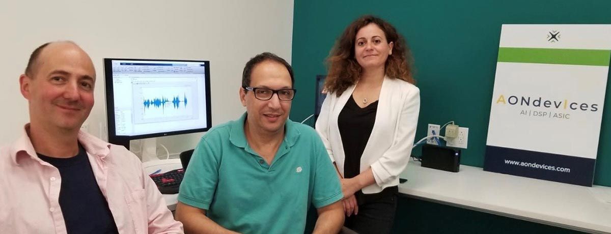 Daniel Schoch (left), Dr. Adil Benyassine, and Mouna El Khatib (right) in the AONDevices office. Computer in background.