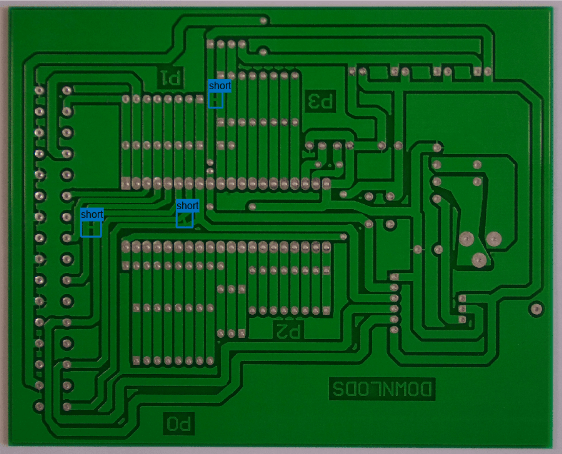 Image of a printed circuit board with three labeled bounding boxes that identify short circuit defects